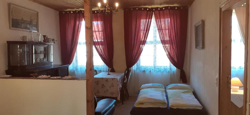- une chambre avec 2 lits, une table et des fenêtres dans l'établissement Schloss Ottendorf, à Bahretal