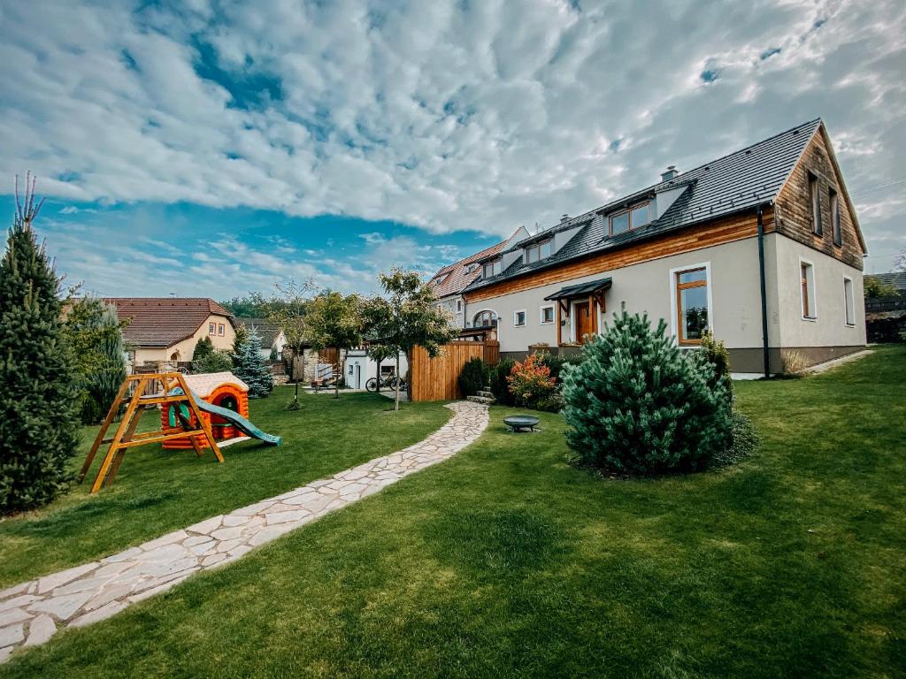 a house with a playground in the yard at Apartments Na Špejcharu in Stříbřec