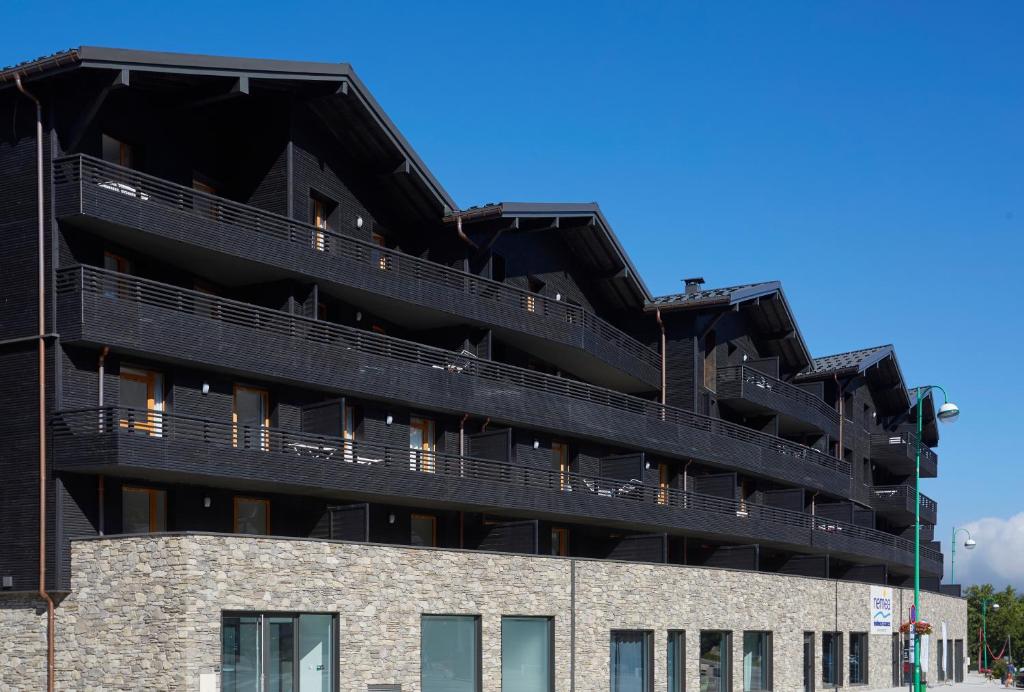 a black building with balconies on the side of it at Résidence Néméa Le Hameau - Les Deux Alpes in Les Deux Alpes