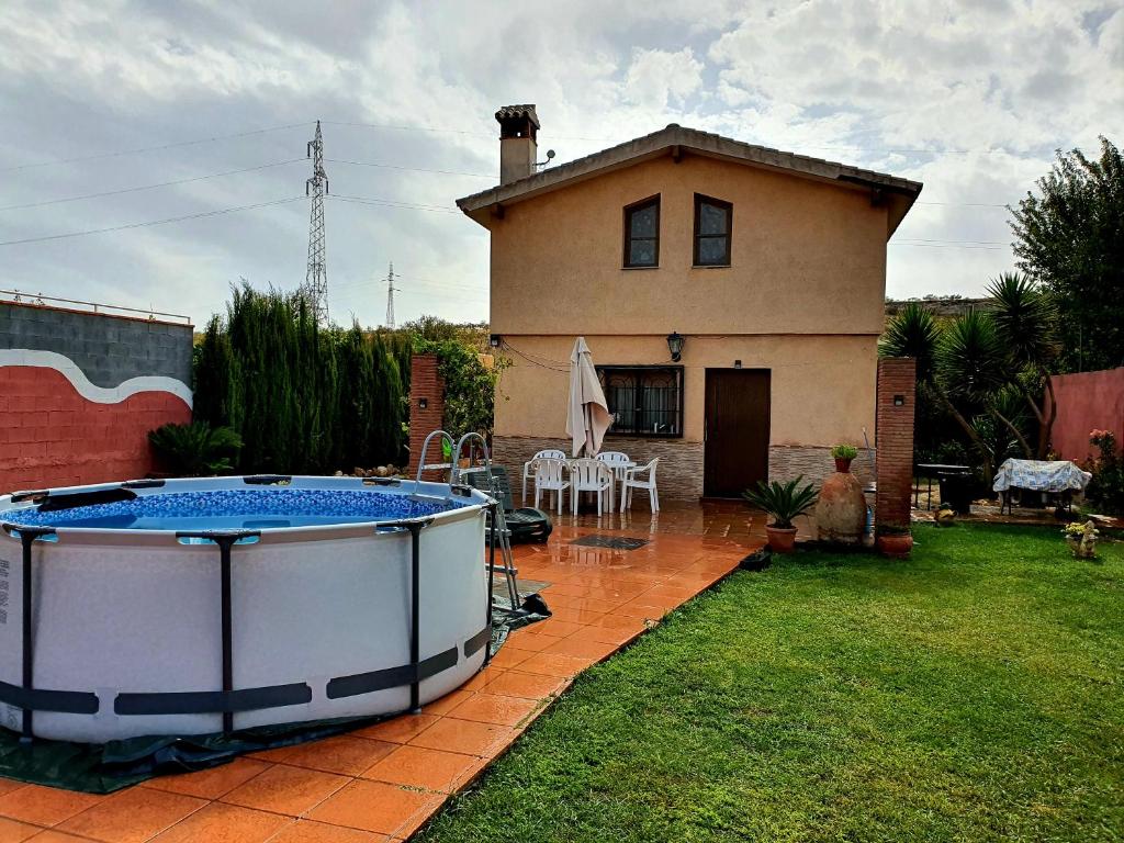 una casa con una grande vasca idromassaggio nel cortile di Casa de campo Padul a Granada