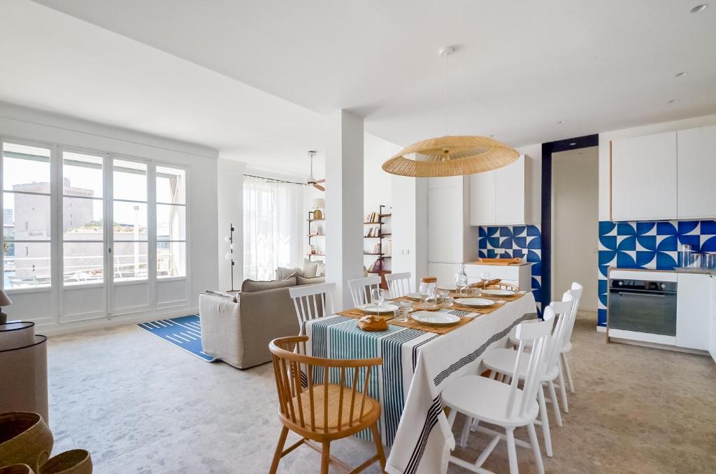 une cuisine et un salon avec une table et des chaises dans l'établissement MASSILIA BLUE - Grand appartement refait à neuf avec vue sur le Vieux Port, à Marseille