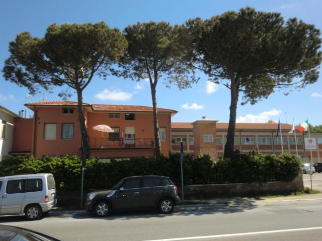 due auto parcheggiate in un parcheggio di fronte a un edificio di Appartamenti Martini - Tirrenia a Pisa