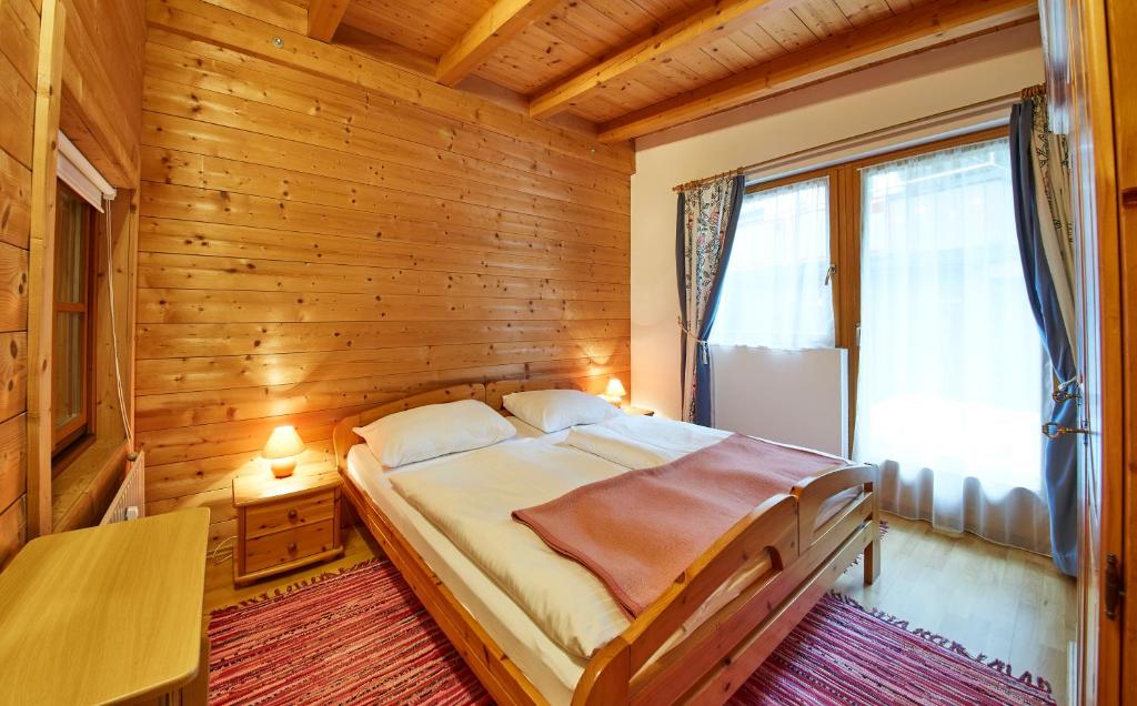 a bedroom with a bed in a wooden room at Appartement Heidi in Viehhofen