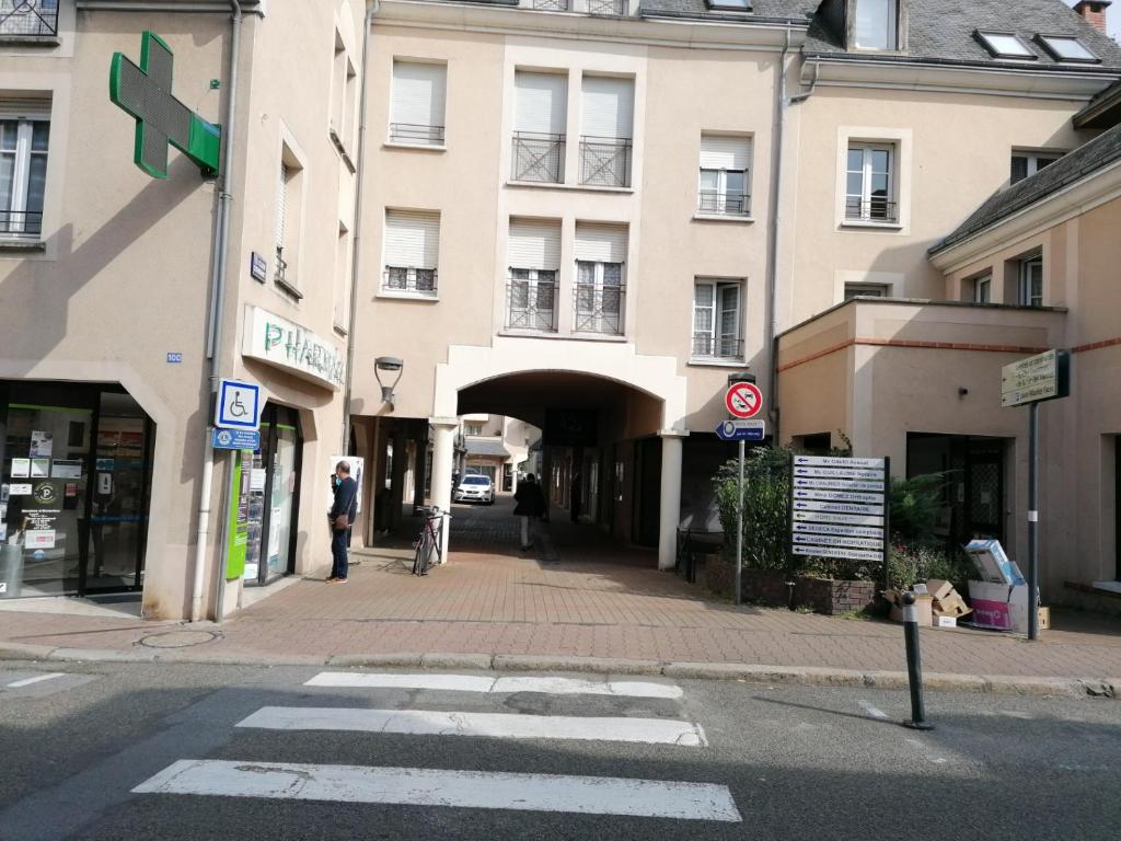 una strada cittadina con un edificio e un cartello stradale di CHARMANT APPARTEMENT CENTRE VILLE LE RONSARD a Nogent-le-Rotrou