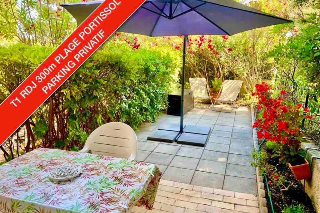 un patio avec une table et un parasol dans l'établissement PORTISSOL T1 RDJ CLIM PARKING PRIVATIF 300m PLAGE, à Sanary-sur-Mer
