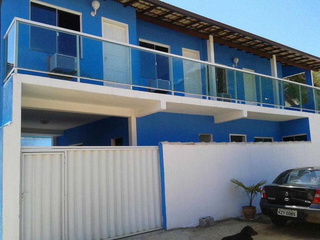 a blue building with a fence and a car parked in front at Recanto do Jack in Búzios