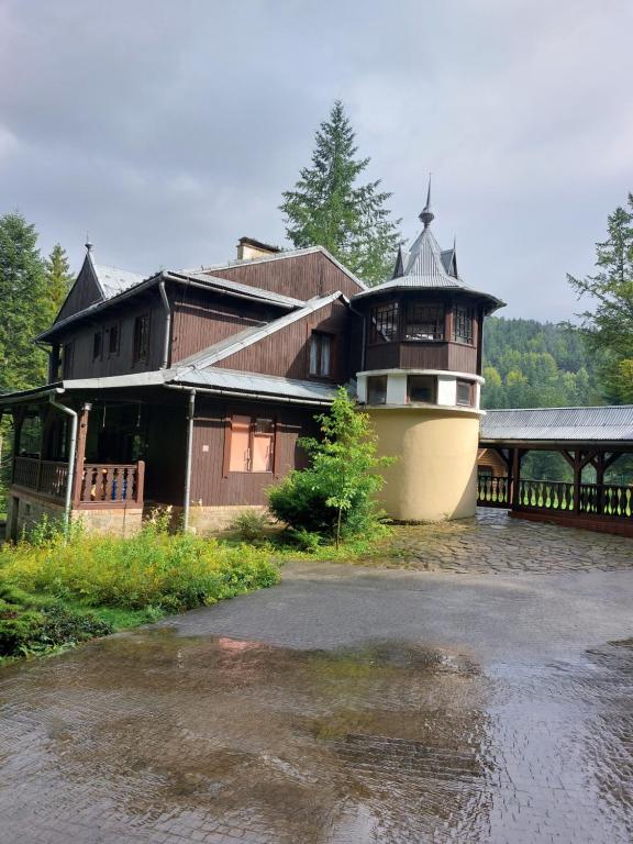 una casa grande con un barco en el agua en Leśna Skawica, en Skawica