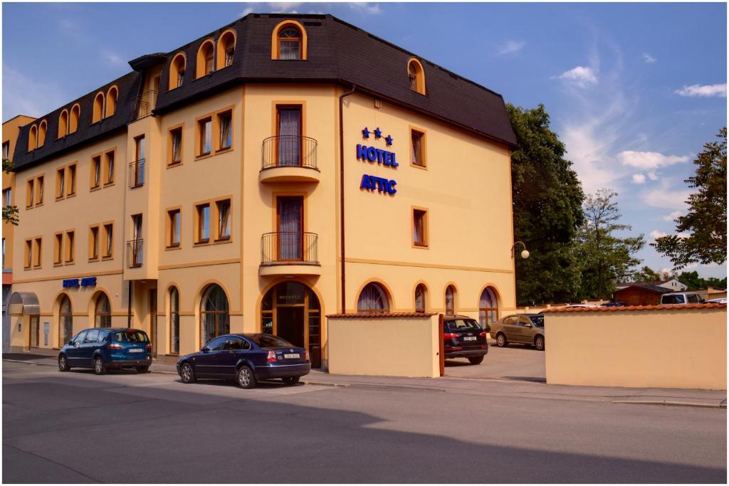 un gran edificio con coches estacionados frente a él en Attic Hotel en Praga