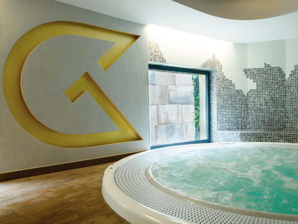 a large tub in a bathroom with a large sign at Golden Tulip Amnéville in Amnéville