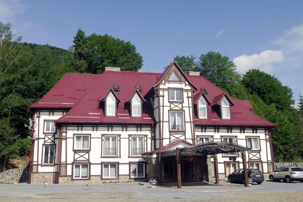 un grand bâtiment blanc avec un toit rouge dans l'établissement Zolota Forel Hotel, à Korostov