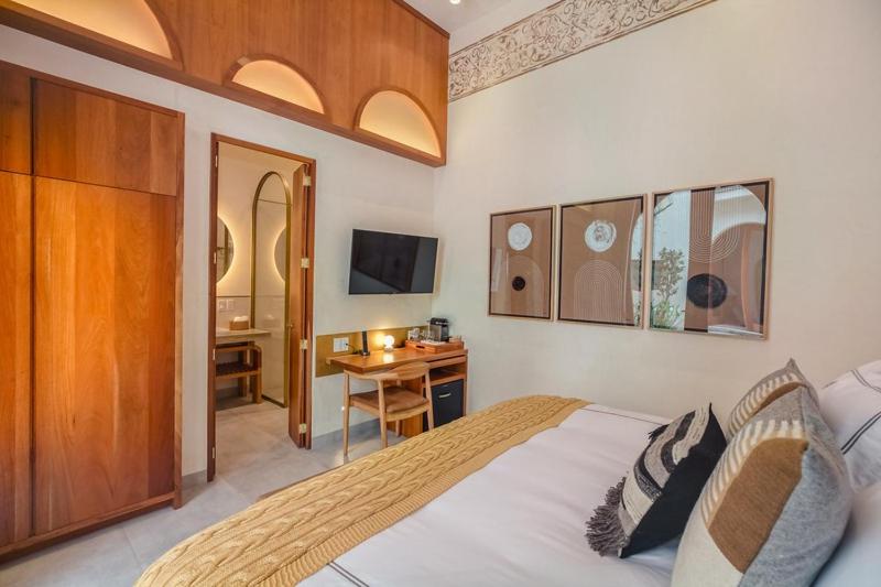 a bedroom with a bed and a desk and a television at Cantera 1910 Hotel Boutique, Destination Hotel in San Miguel de Allende