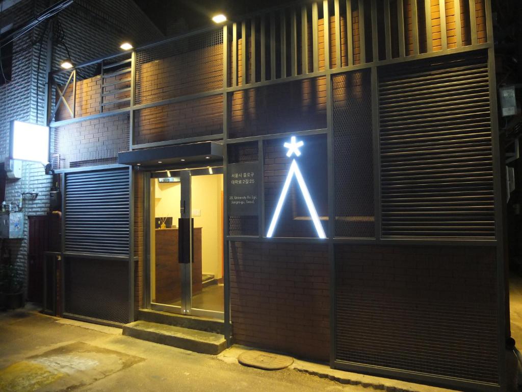 une entrée à un bâtiment avec un panneau sur celui-ci dans l'établissement Star Hostel Seoul Dongdaemun, à Séoul