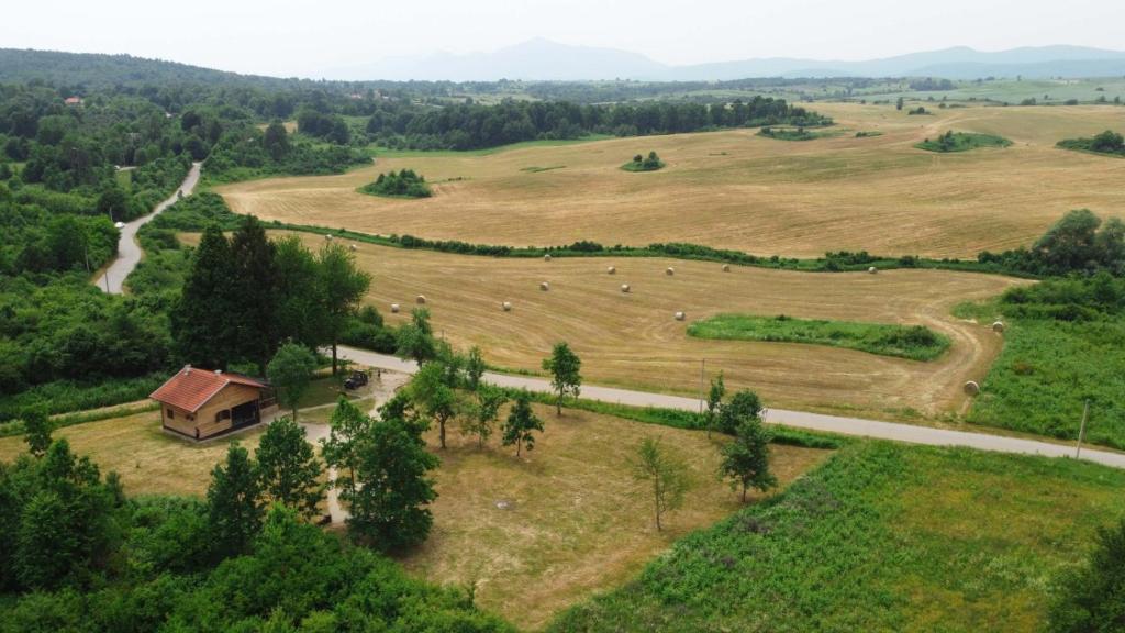 an aerial view of a field with a house and a road at Evergreen house Plitvice in Rakovica