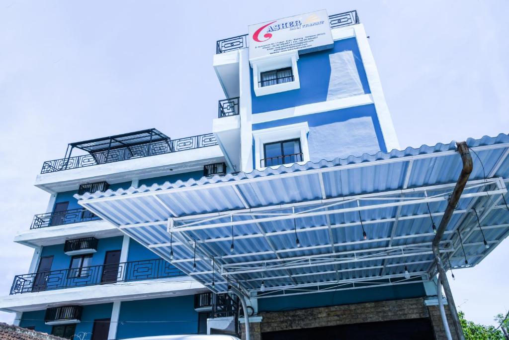 a blue and white building with a metal roof at Asher Bali Transit in Kuta