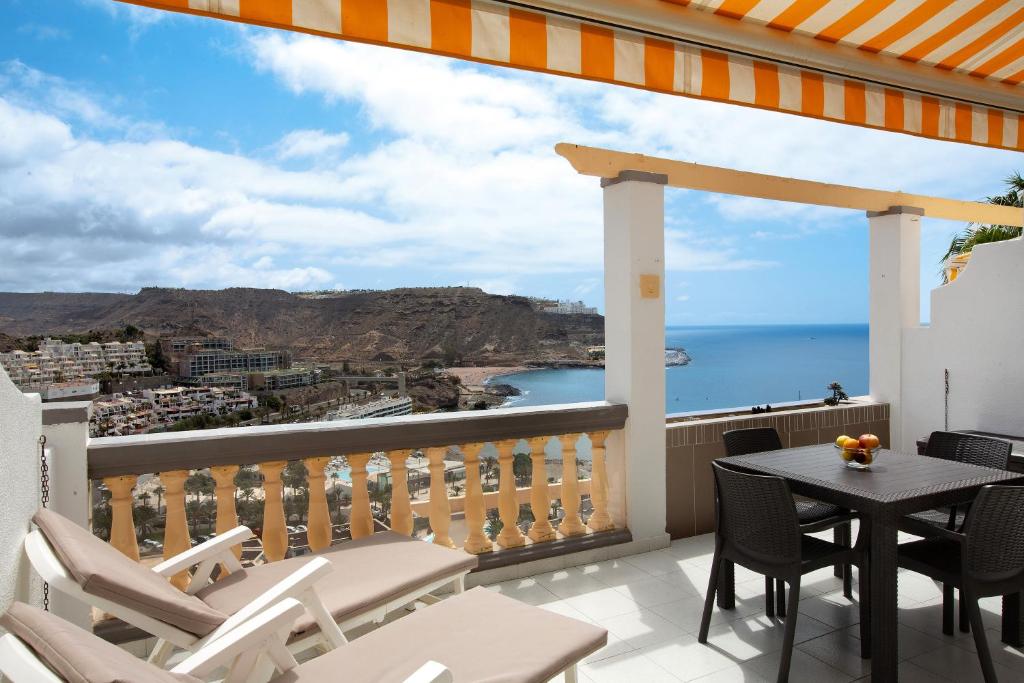 een balkon met een tafel en stoelen en uitzicht op de oceaan bij Sea View Apartment en Mogán in Playa del Cura