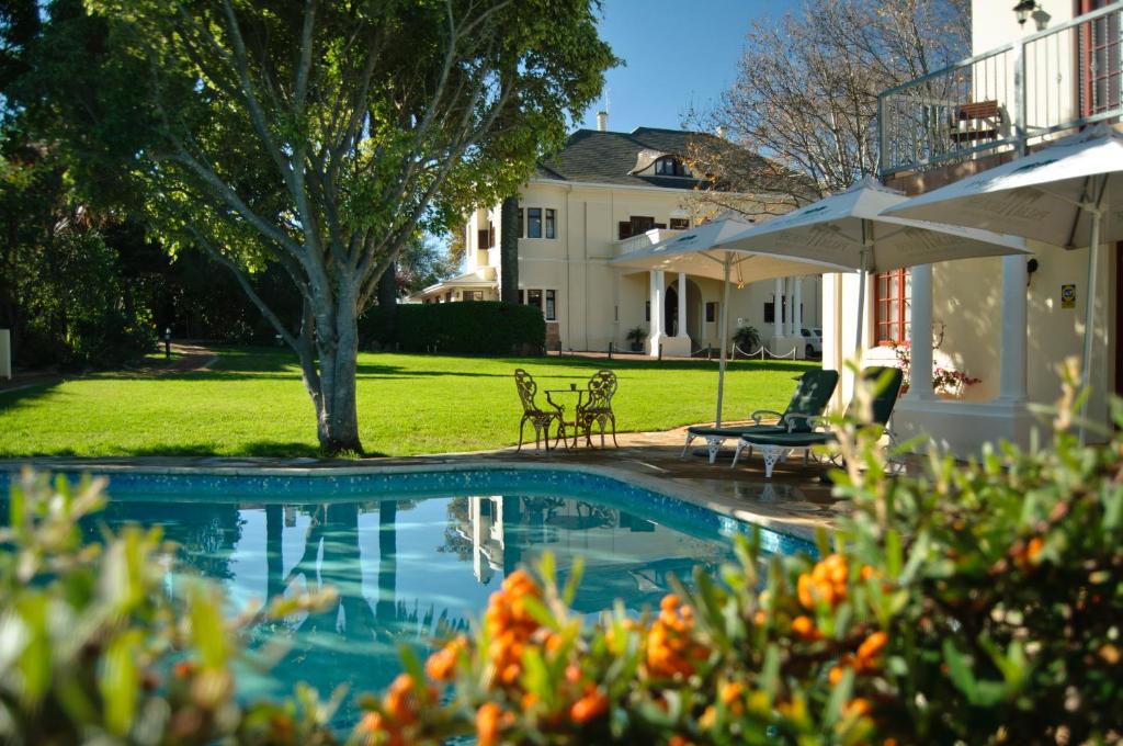 a swimming pool in the yard of a house at Palm House Luxury Guest House in Cape Town