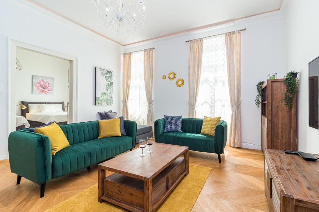 un soggiorno con 2 divani verdi e un tavolino da caffè di Apartment Augier - Elegant & Spacious - City Centre a Pola (Pula)