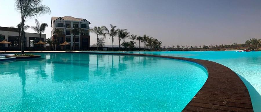 a large swimming pool with blue water and palm trees at 1152 @The Blyde Riverwalk - Crystal Lagoon in Pretoria