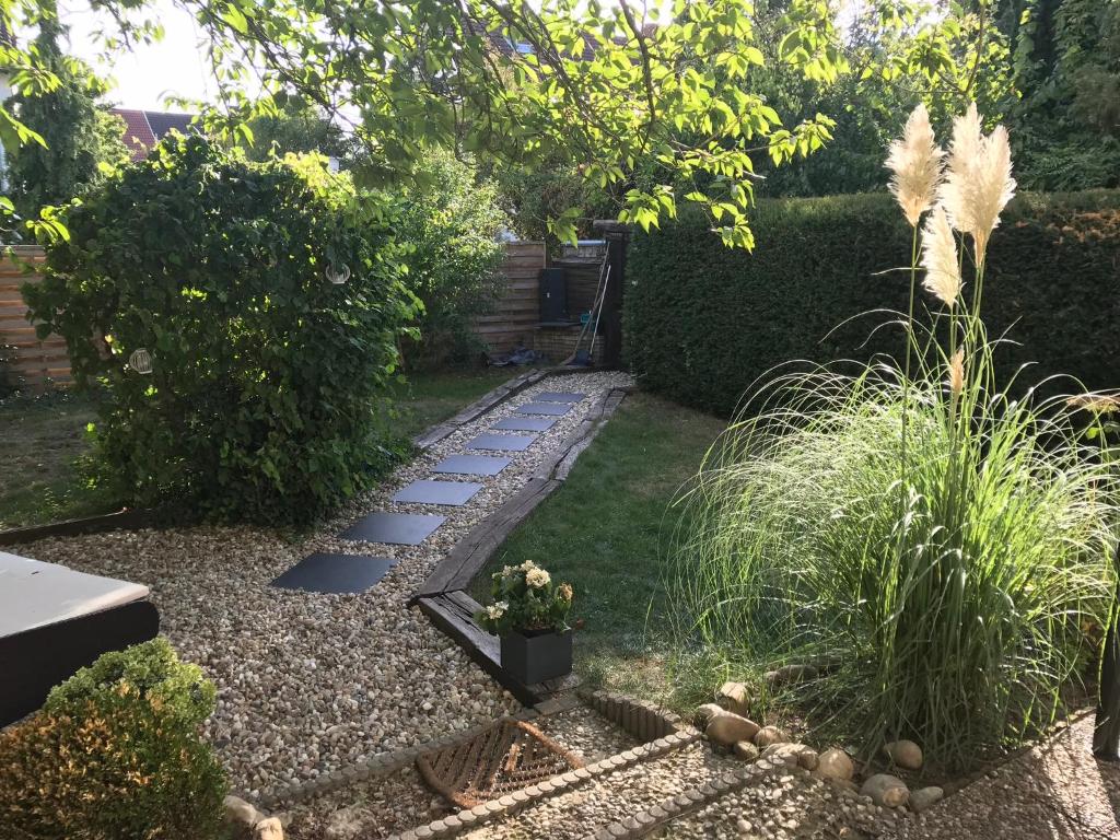 a backyard with a garden with a path and plants at Gästehaus zur Uni Klinik Exklusives Apartment mit Küche und Badezimmer in Homburg