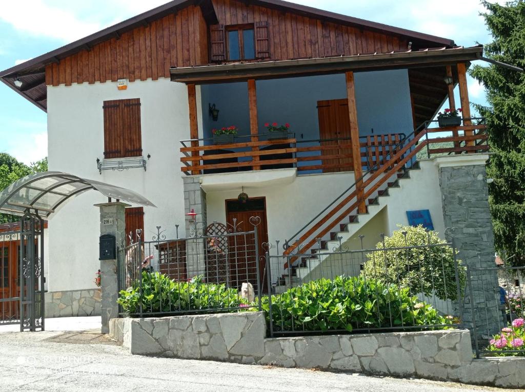 a house with a balcony and a staircase at Villa Angela primo piano appartamento in Chiusa di Pesio