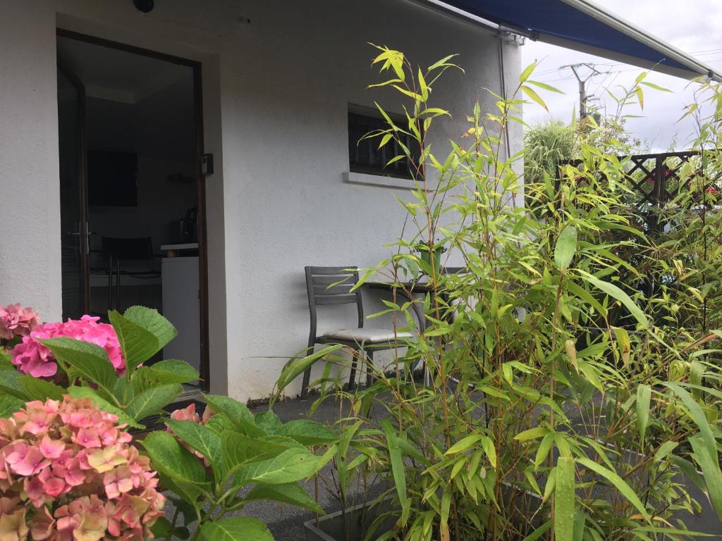un porche con una silla y algunas plantas y flores en 2 person Apartment Ascain en Ascain