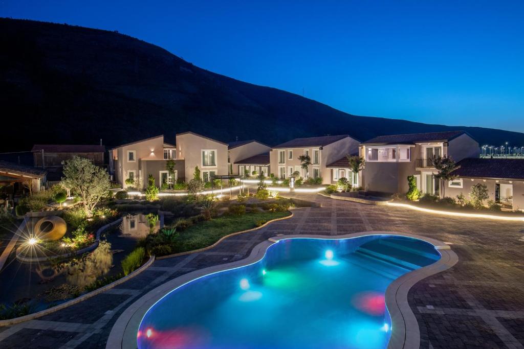un'immagine di una casa con piscina di notte di Hotel Della Piana ad Avezzano