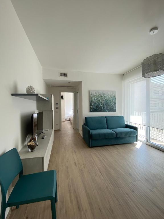 a living room with a blue couch and a television at Aura Marina Casa Vacanze in Polignano a Mare