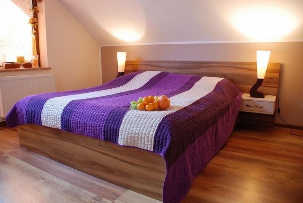 a bedroom with a bed with a bowl of fruit on it at Pokoje Gościnne u Anety in Wicko