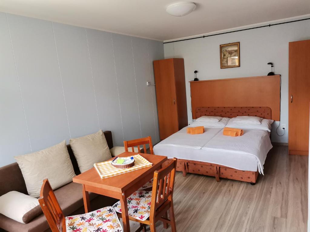 1 dormitorio con cama, mesa y sofá en Rózsa Apartman, en Gyula