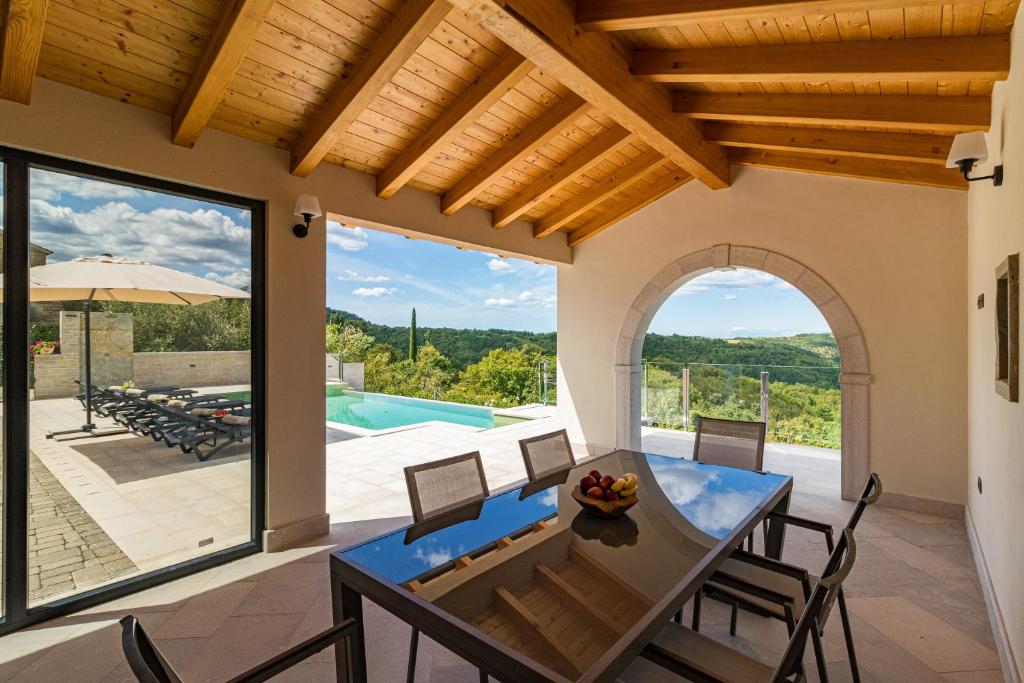 jadalnia ze stołem i krzesłami oraz basenem w obiekcie Villa Grazia - with heated salt water Pool w mieście Pazin