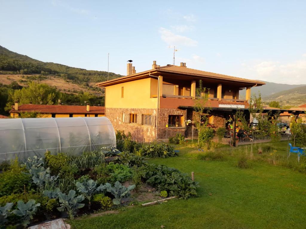 una casa con un jardín delante de ella en Hotel Villaneila, en Neila