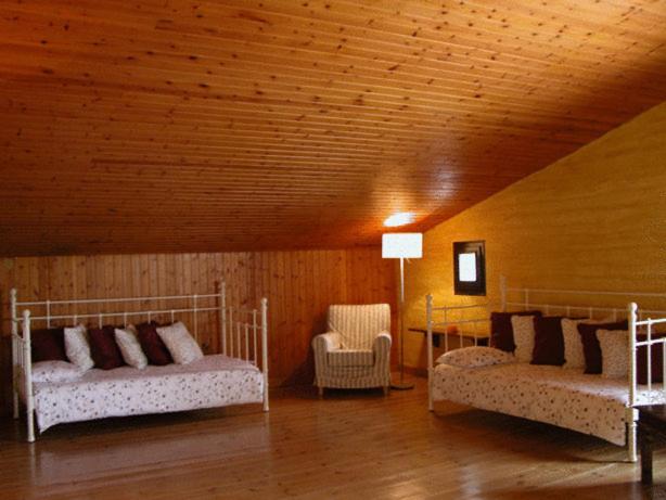 een kamer met 2 bedden en een stoel bij Masia Vista Hermosa in Vallromanas
