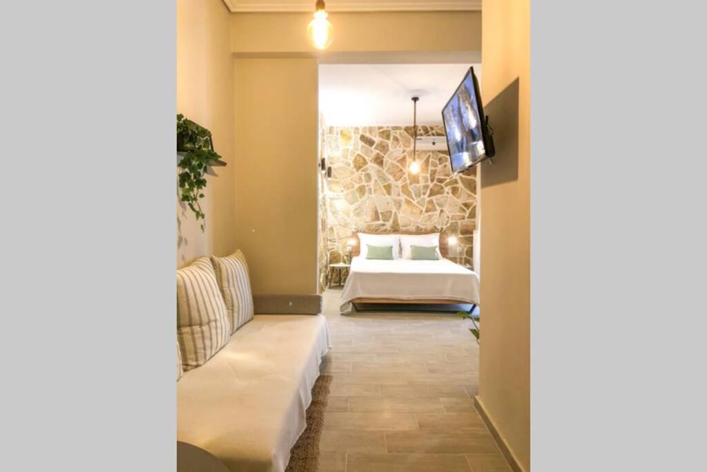 ein Hotelzimmer mit einem Bett und einem TV in der Unterkunft Your cozy downtown home - Studio in Larisa