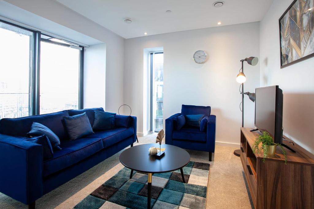 a living room with a blue couch and a table at Gorgeous 2 Bedroom Apartment in Manchester in Manchester
