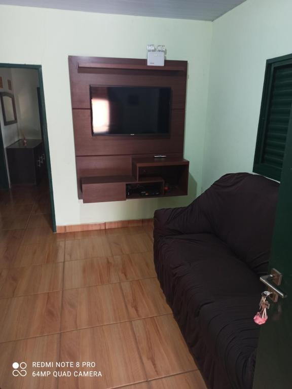 un soggiorno con divano e TV a schermo piatto di Chácara Nilton soares a São José da Barra