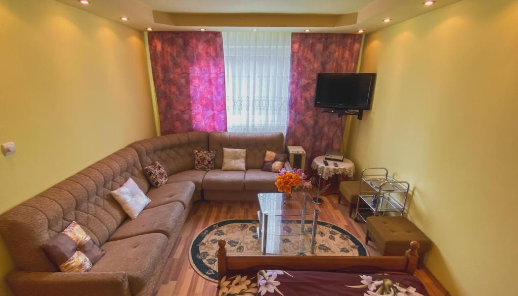 a living room with a couch and a tv at Apartament Cristian in Geoagiu Băi