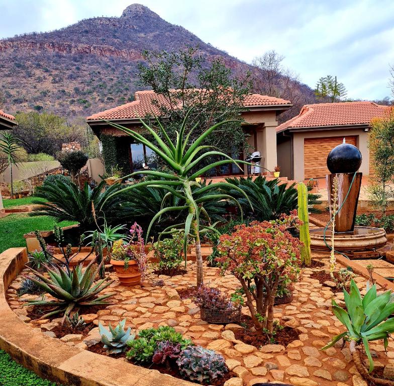 a garden with plants and flowers in front of a house at 66 Sharalumbi Wildlife Estate in Lydenburg