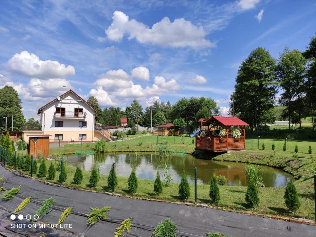 una casa y un barco en un río junto a una casa en Nad Cedronem, en Wambierzyce