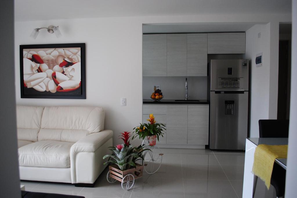a living room with a white couch and a kitchen at Near El Poblado,New Modern,Turco,Jacuzzi & Pools in Sabaneta
