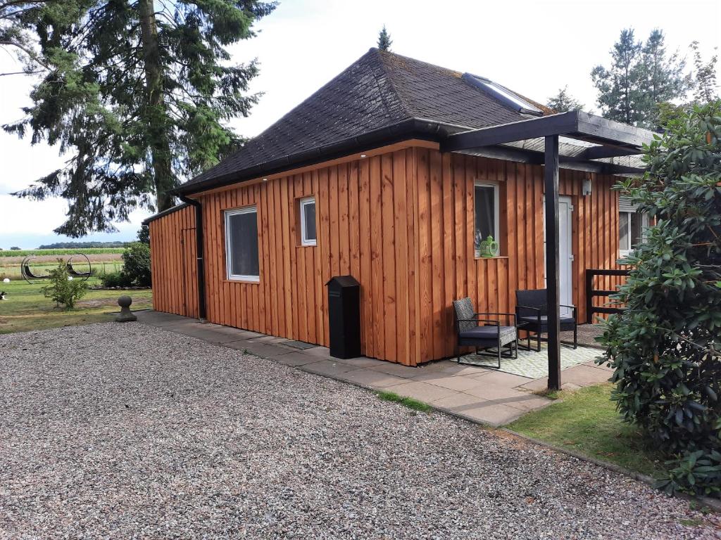 Cabaña de madera grande con porche y patio en Ferienhaus Max mit Sauna, en Rehburg-Loccum