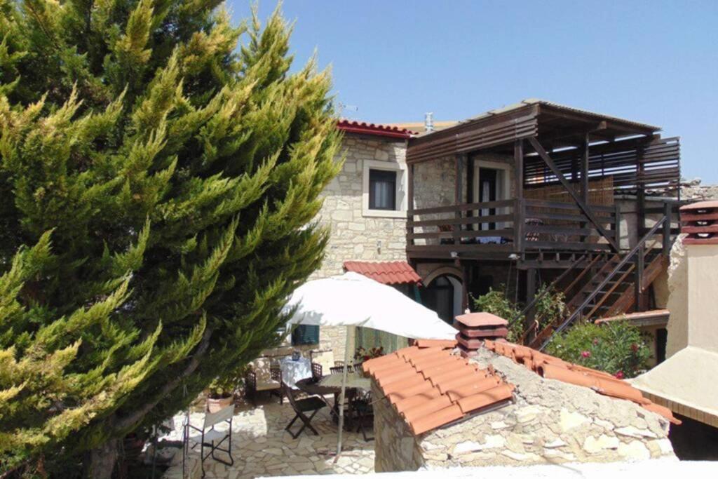 a house with an umbrella and a table with an umbrella at Villa Strata (a path to Psiloritis mountain) in Kardhamianá