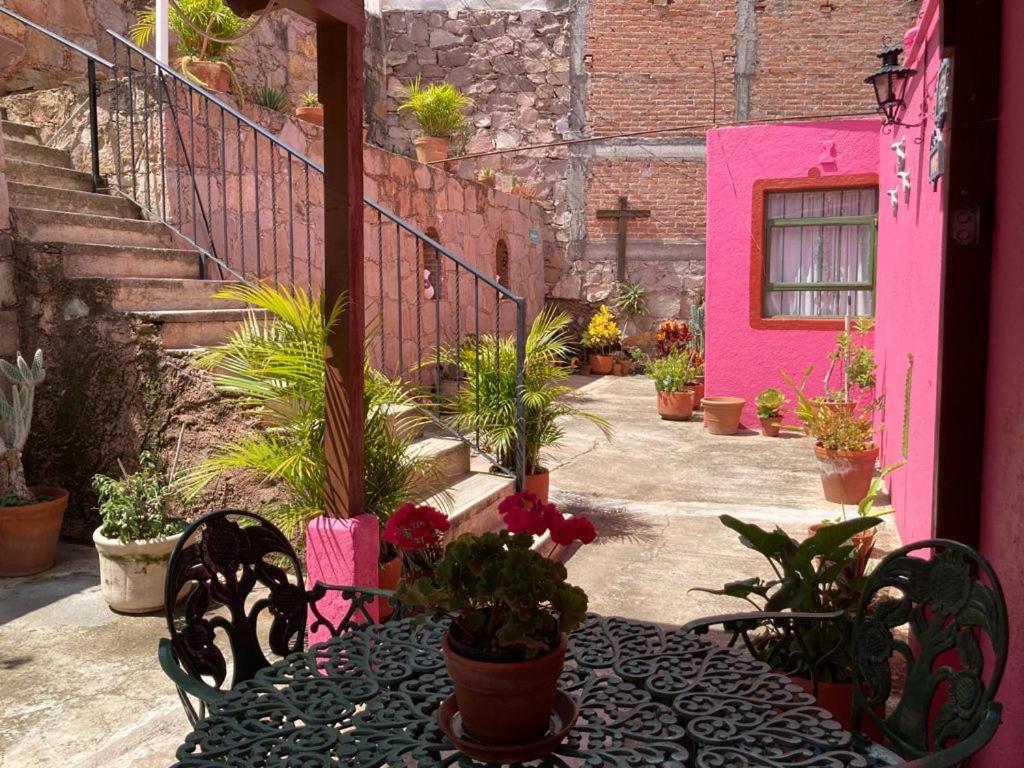 a patio with a table and chairs with potted plants at Manzano B&B in Guanajuato