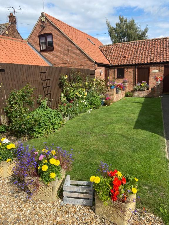 
a garden filled with flowers and plants next to a building at Willow Tree Cottages in Newark upon Trent
