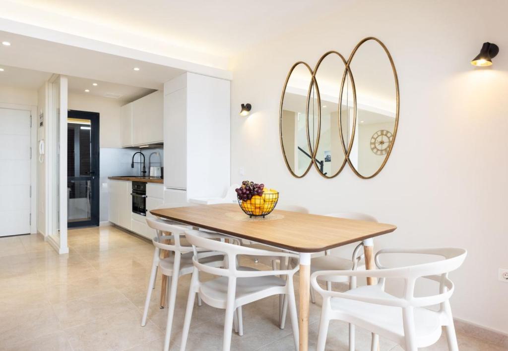 a kitchen and dining room with a wooden table and chairs at Sunny Castillo Apartment in Costa de Antigua