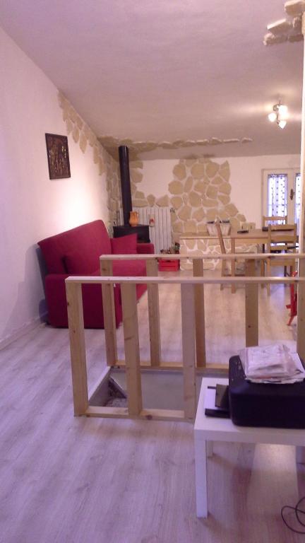 een woonkamer met een rode bank en een tafel bij Vetralla Terme Viterbo in Vetralla