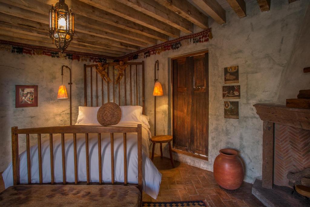 una camera con un letto in una stanza con camino di Hacienda Las Amantes a San Miguel de Allende