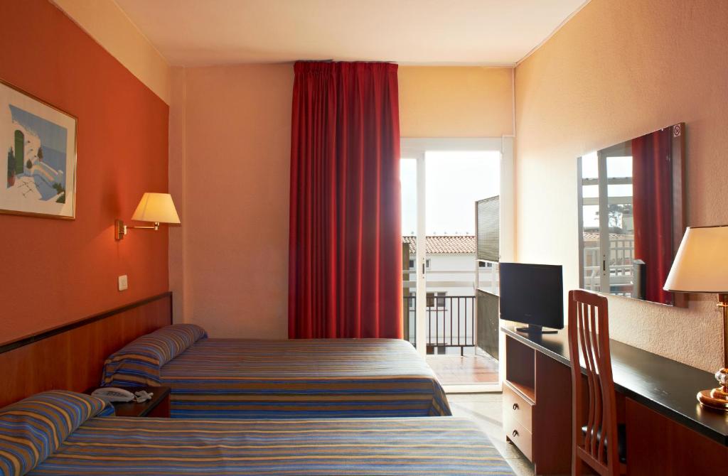 une chambre d'hôtel avec un lit et une fenêtre dans l'établissement BLUESEA Copacabana, à Lloret de Mar
