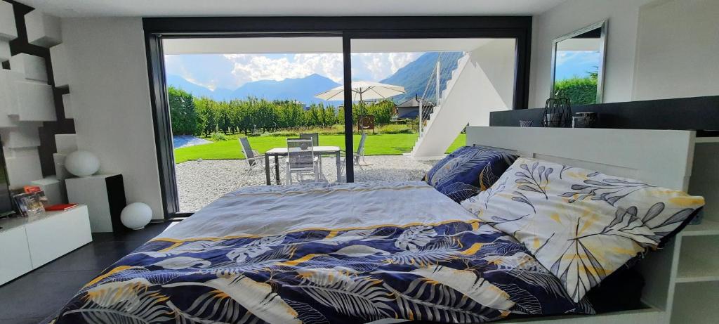 a bedroom with a bed with a view of a patio at Alps Spirits - B&B Studio in Fully