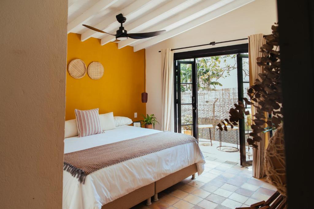 1 dormitorio con 1 cama con pared amarilla en Hotel Boutique Quinta Ladera, en Medellín