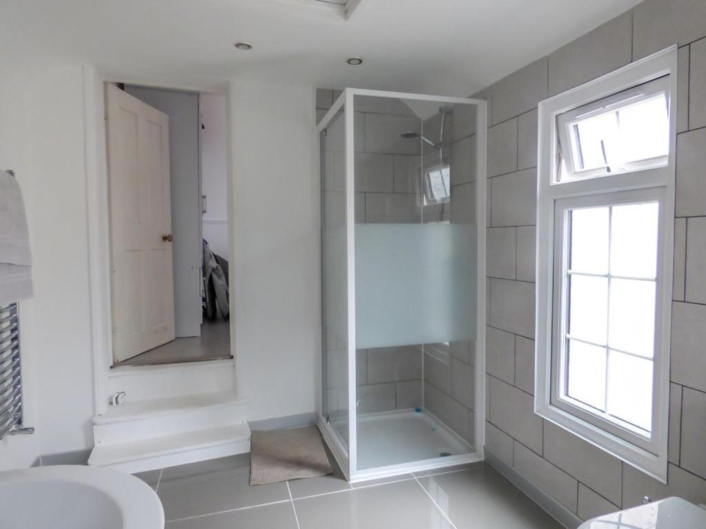 a bathroom with a shower with a sink and a window at Large Bright Sunny En-suite Bedroom in Northfleet